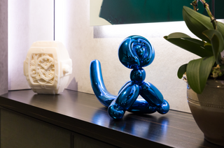 At the Hublot Koons evening in London, Jeff Koons’ blue Balloon Monkey (2017) sits on a dark shelf beside a white sculpted watch case and an orchid.
