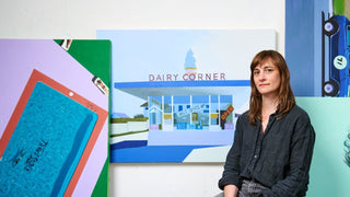 Jessica Brilli sitting in front of her works. She is one of the modern women artists featured at the Maddox Gallery International Women’s Day art exhibition, HER.