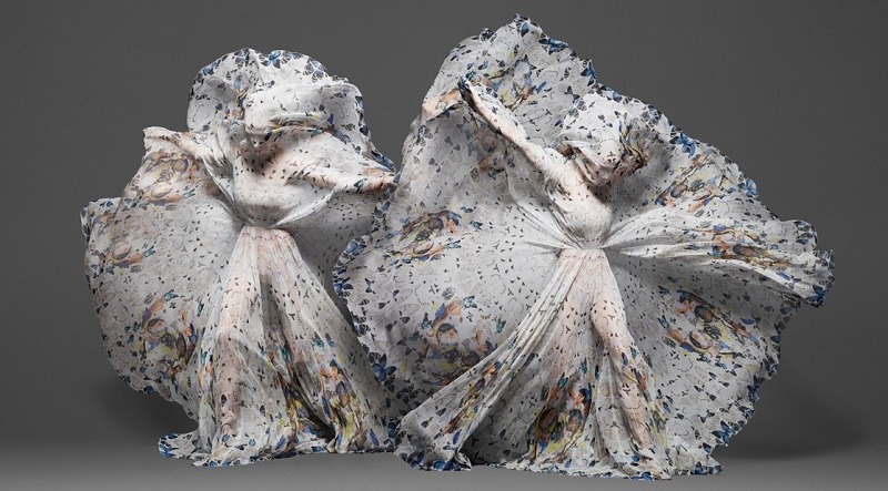 Models dance while covered in a giant Alexander Mcqueen Damien Hirst scarf as part of one of the most famous art fashion partnerships.