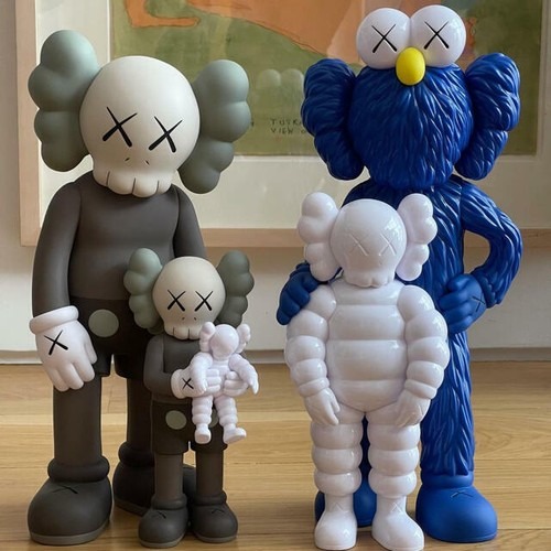 Five life size KAWS family figures seem to huddle together in a gallery space.