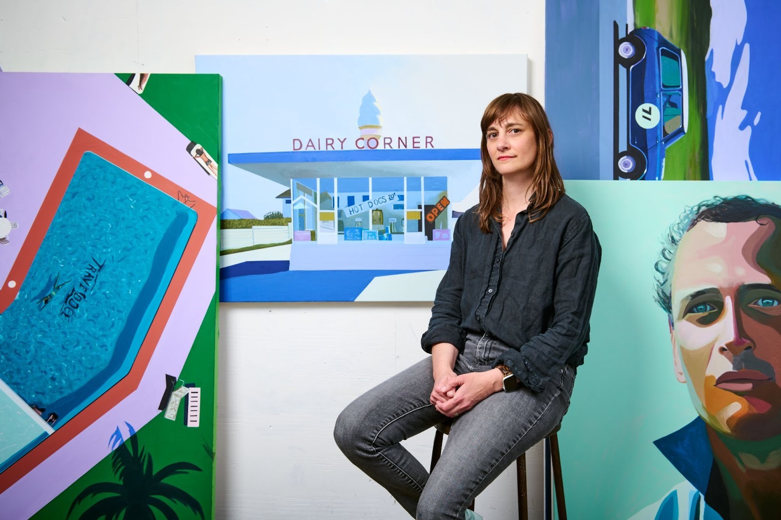 Jessica Brilli sitting in front of her works. She is one of the modern women artists featured at the Maddox Gallery International Women&rsquo;s Day art exhibition, HER.