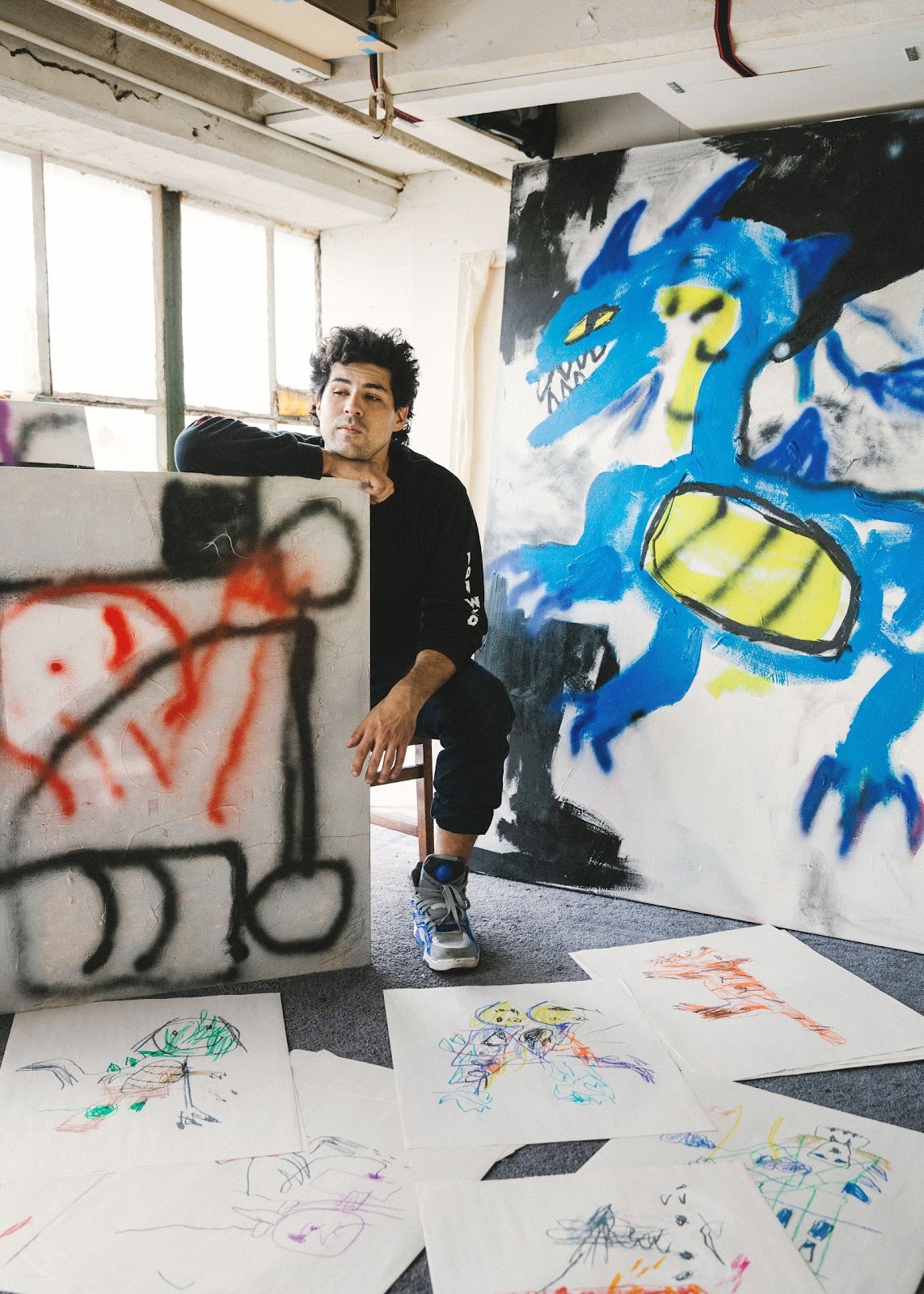 Famous Naive artist Robert Nava sits in his studio, surrounded by his Contemporary Naive art works.